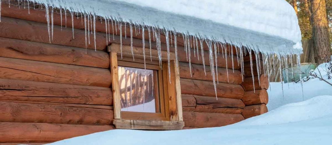 Icicles hanging from roof edge indicating ice buildup and winter roof issues